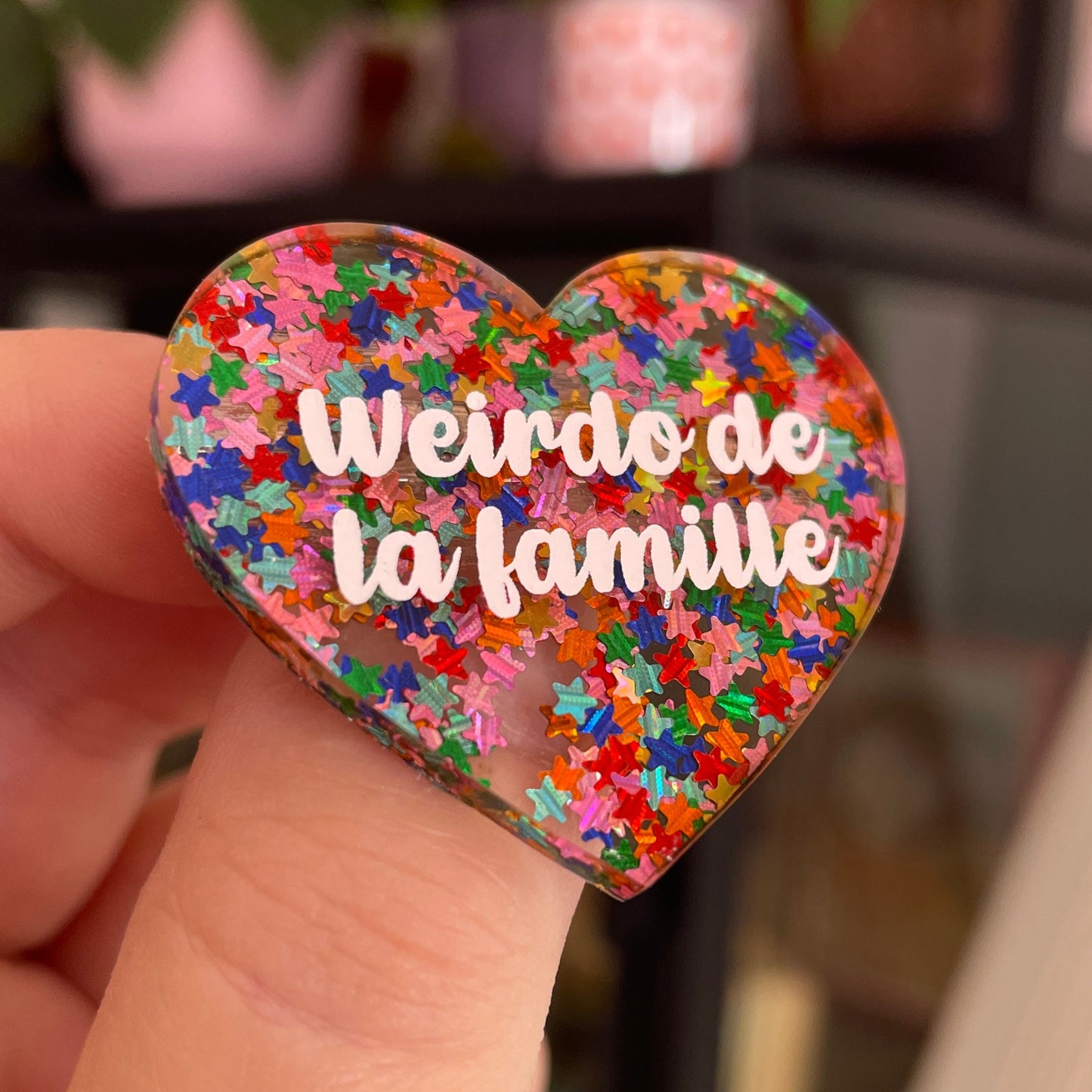 Broche "Weirdo de la famille" en acrylique semi-transparente avec des confettis étoiles multicolores
