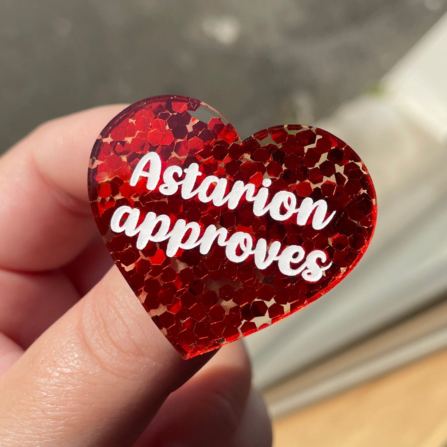 Broche "Astarion approves" en acrylique semi-transparente avec des confettis rouges