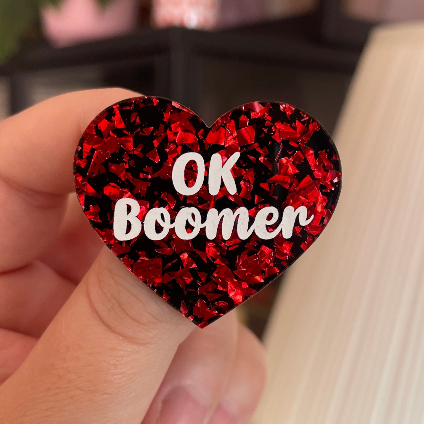 Broche "OK Boomer" en acrylique noire avec des éclats de confettis rouges