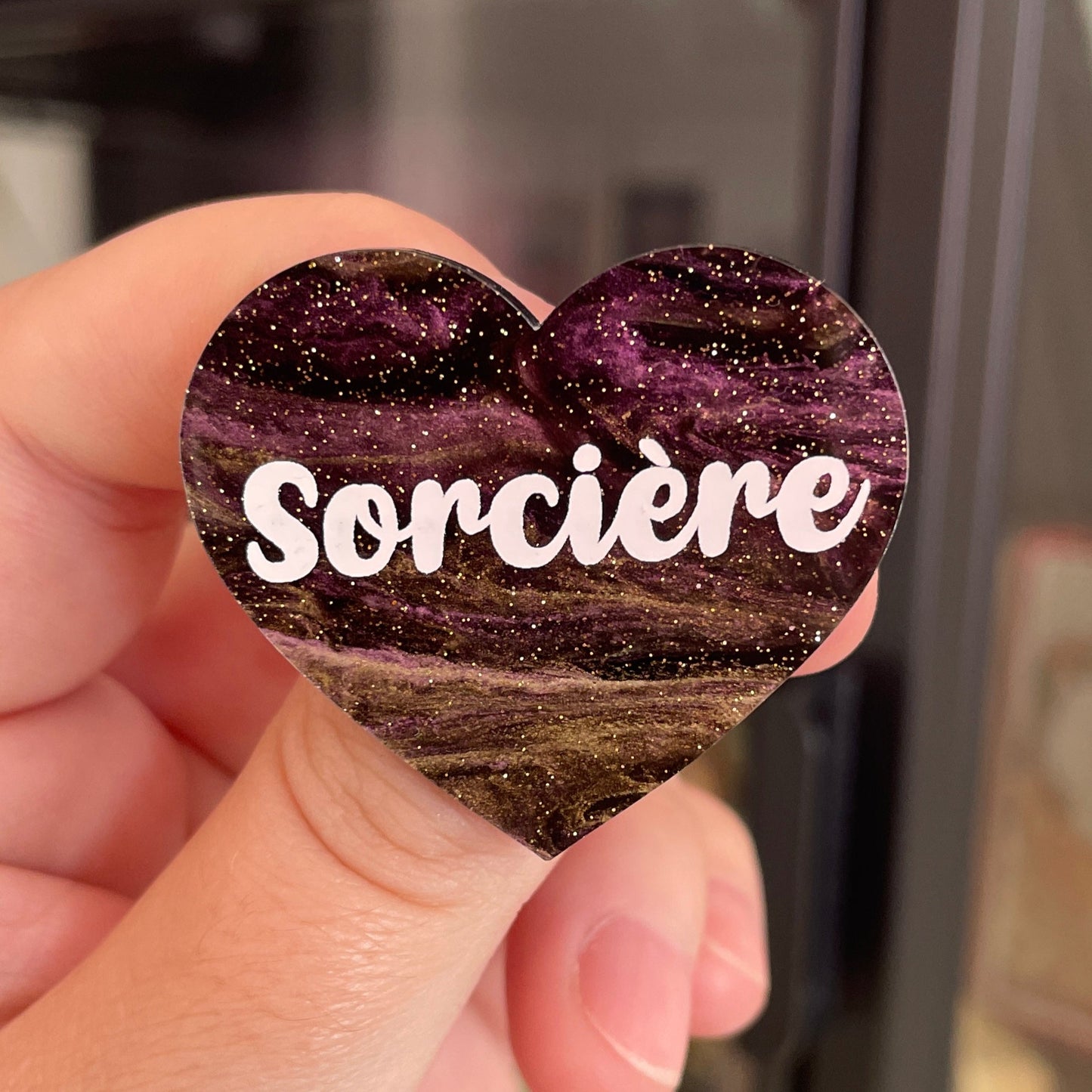 Broche "Sorcière" en acrylique marbrée noire, dorée et violette à paillettes