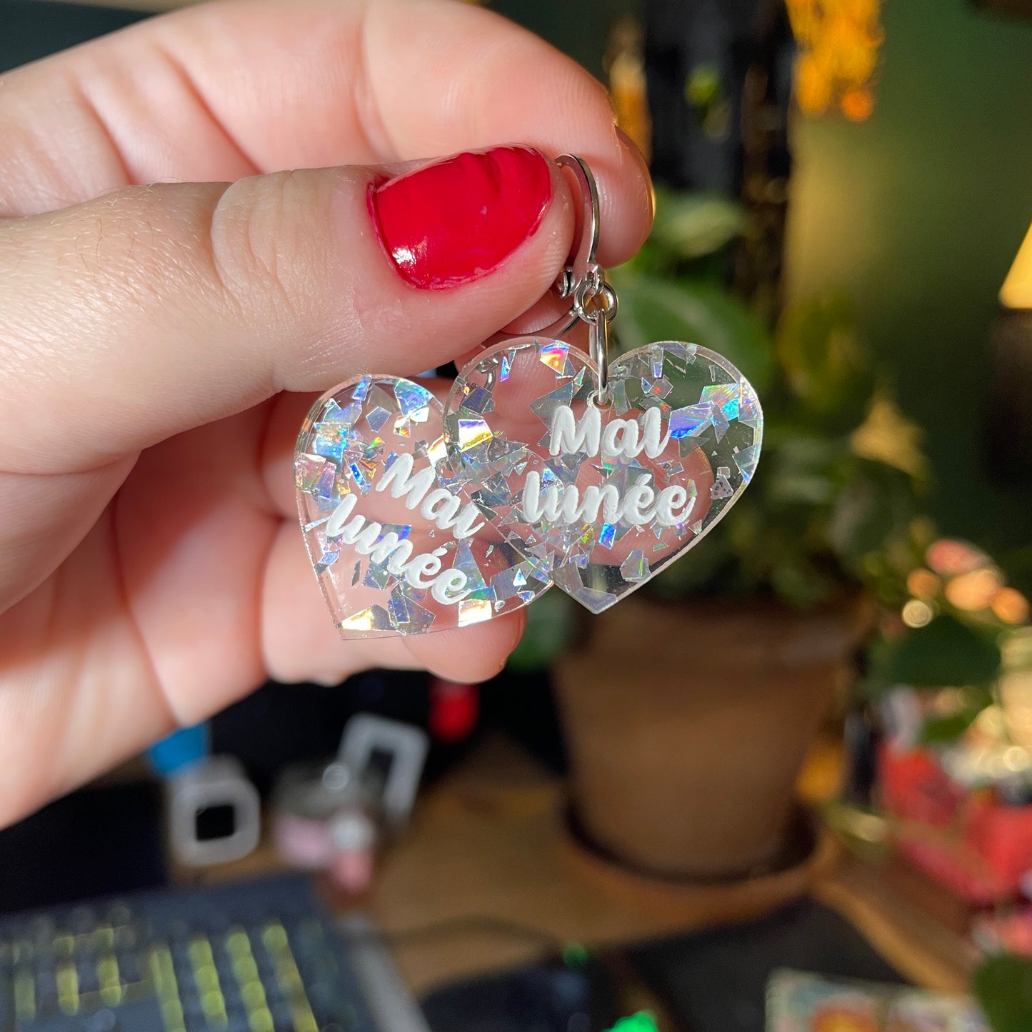 Paire de boucles d'oreilles "Mal lunée" en acrylique transparente avec des éclats de confettis argentés