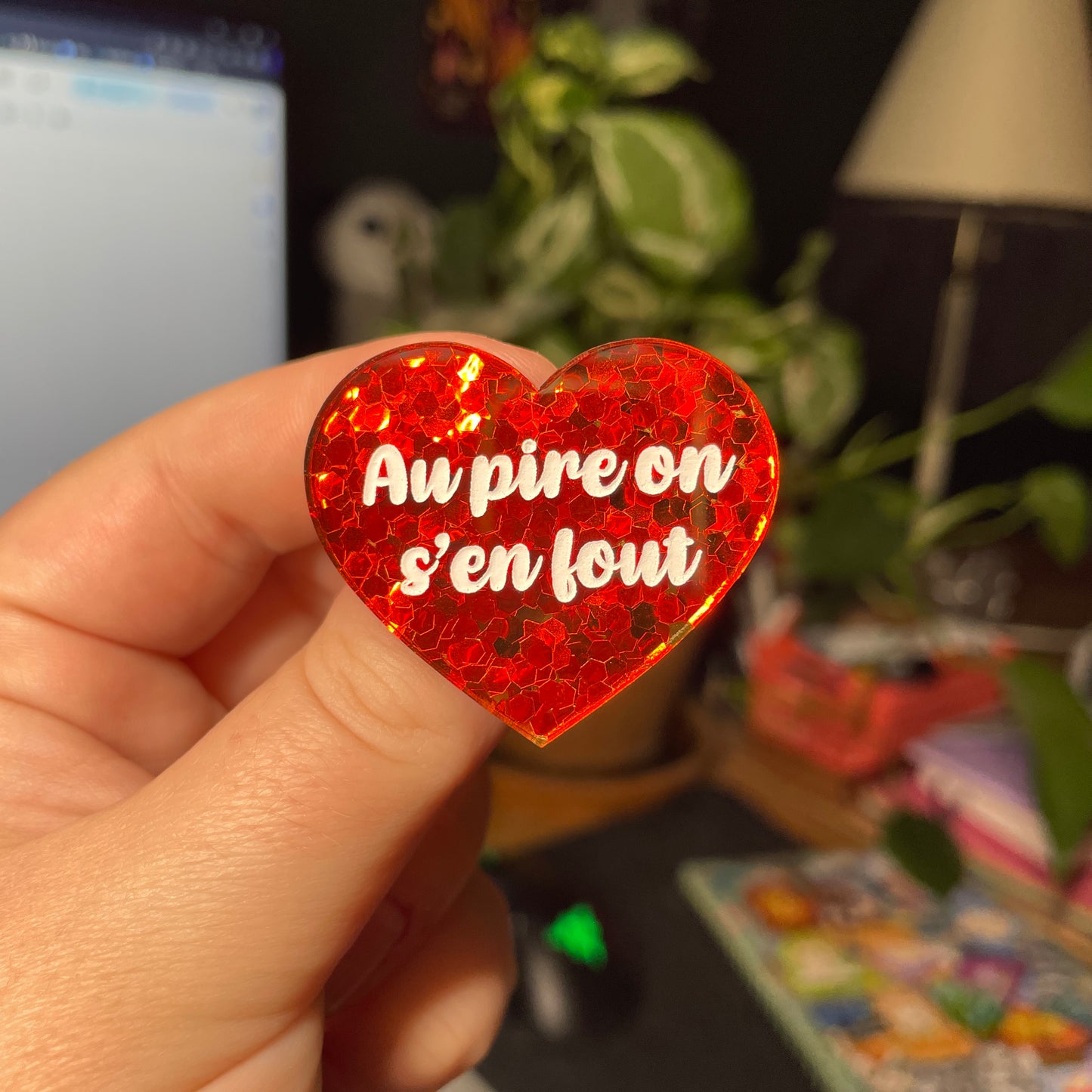 Broche "Au pire on s'en fout" en acrylique semi transparente avec des confettis rouges