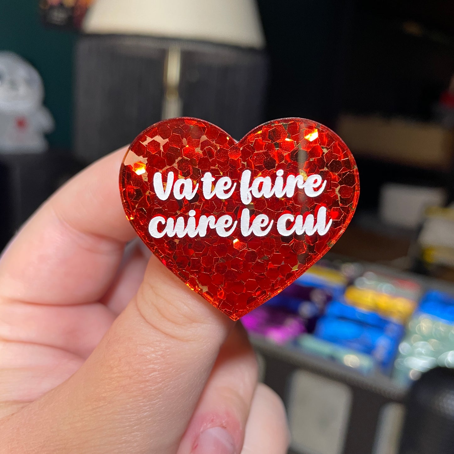 Broche "Va te faire cuire le cul" en acrylique semi transparente avec des confettis rouges