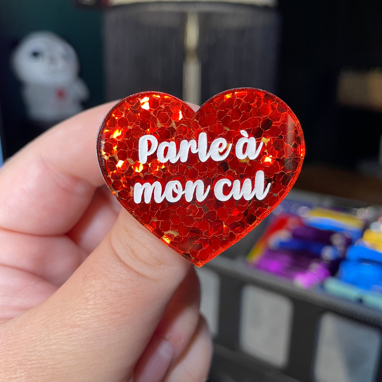 Broche "Parle à mon cul" en acrylique semi transparente avec des confettis rouges