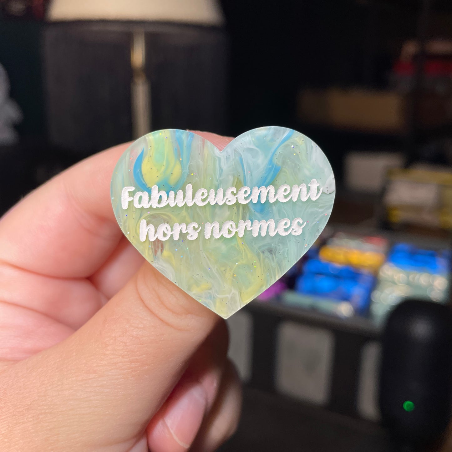 Broche "Fabuleusement hors normes" en acrylique semi transparente marbrée bleue et jaune à paillettes
