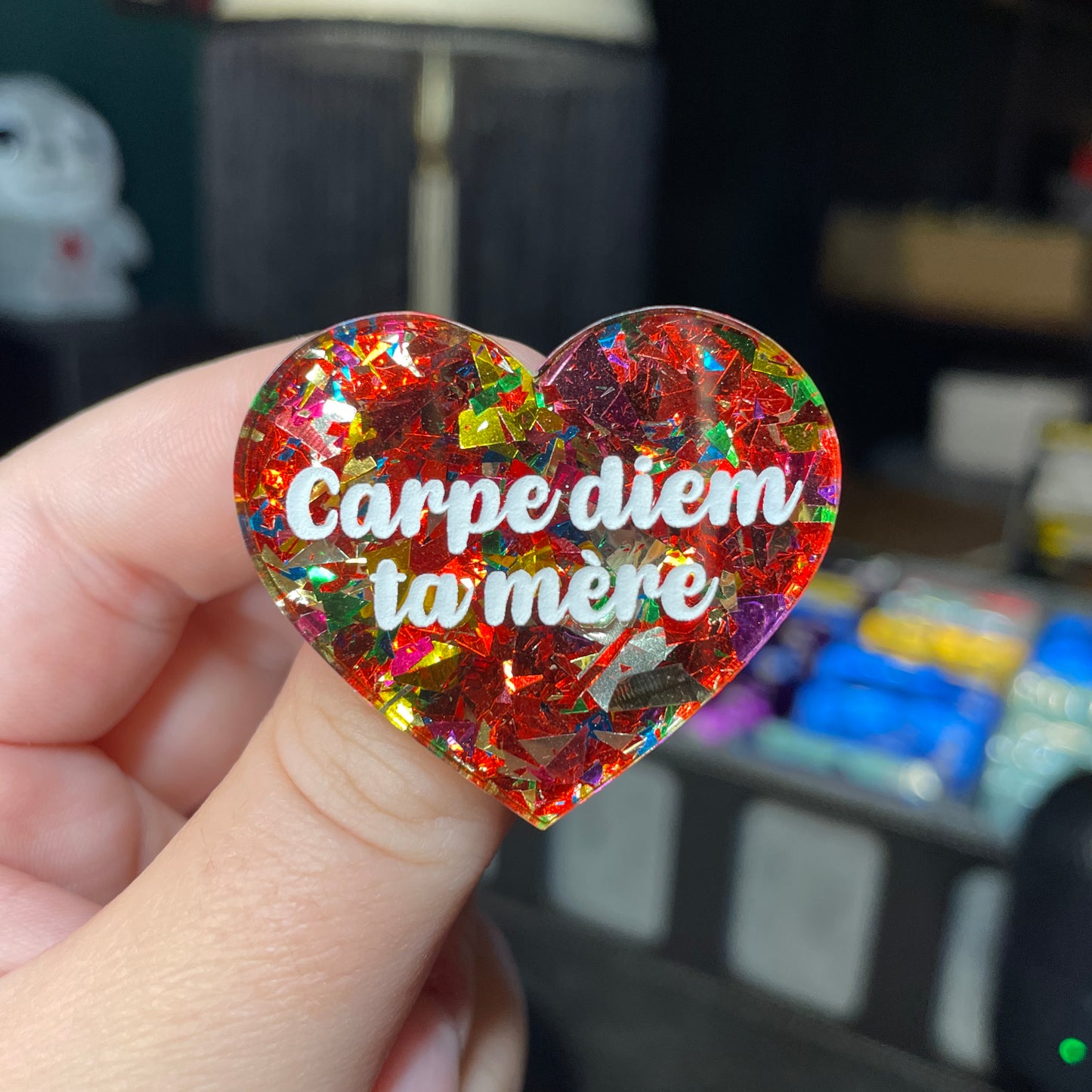 Broche "Carpe diem ta mère" en acrylique transparente avec des éclats de confettis rouges et multicolores