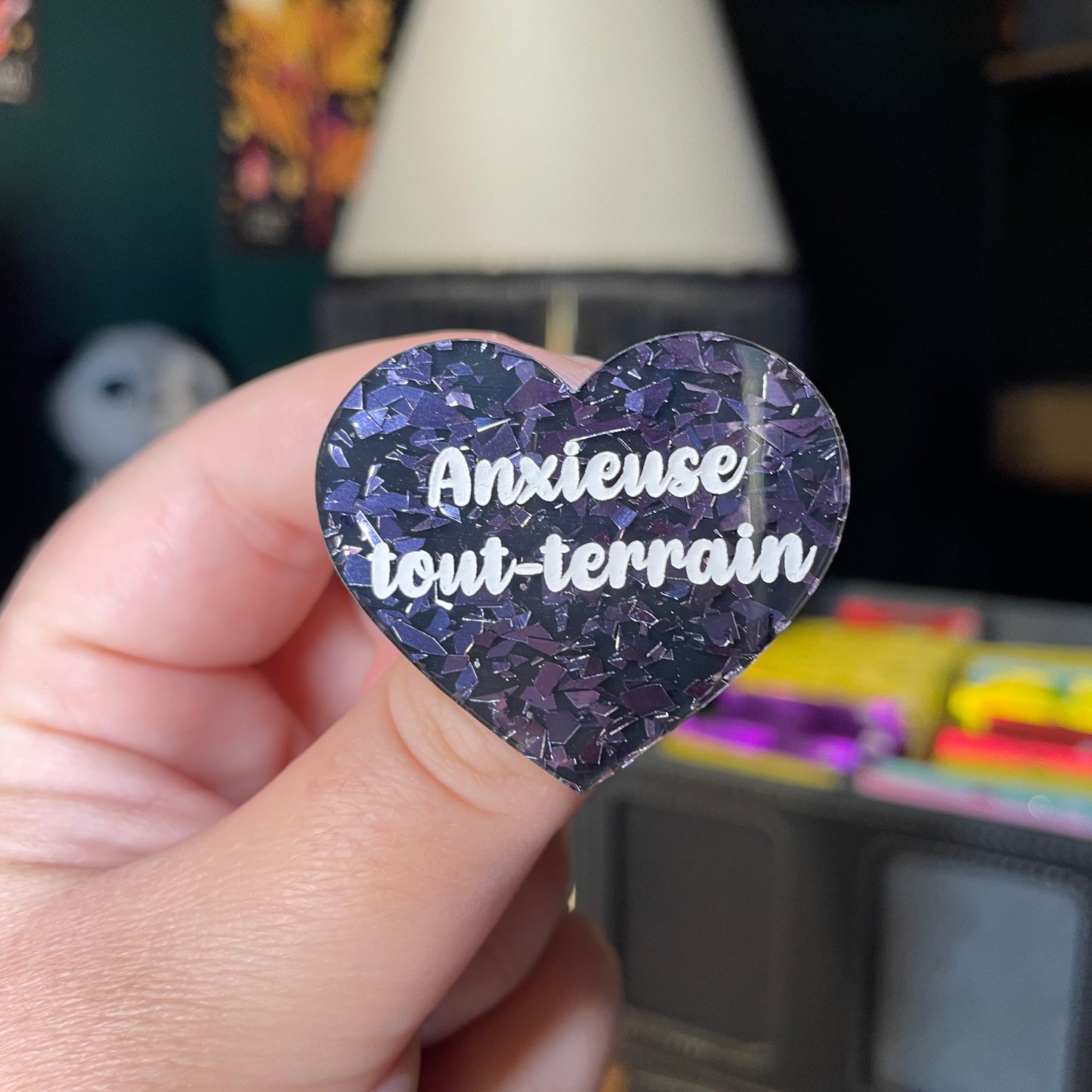 Broche "Anxieuse tout-terrain" en acrylique noire avec des éclats de confettis gris