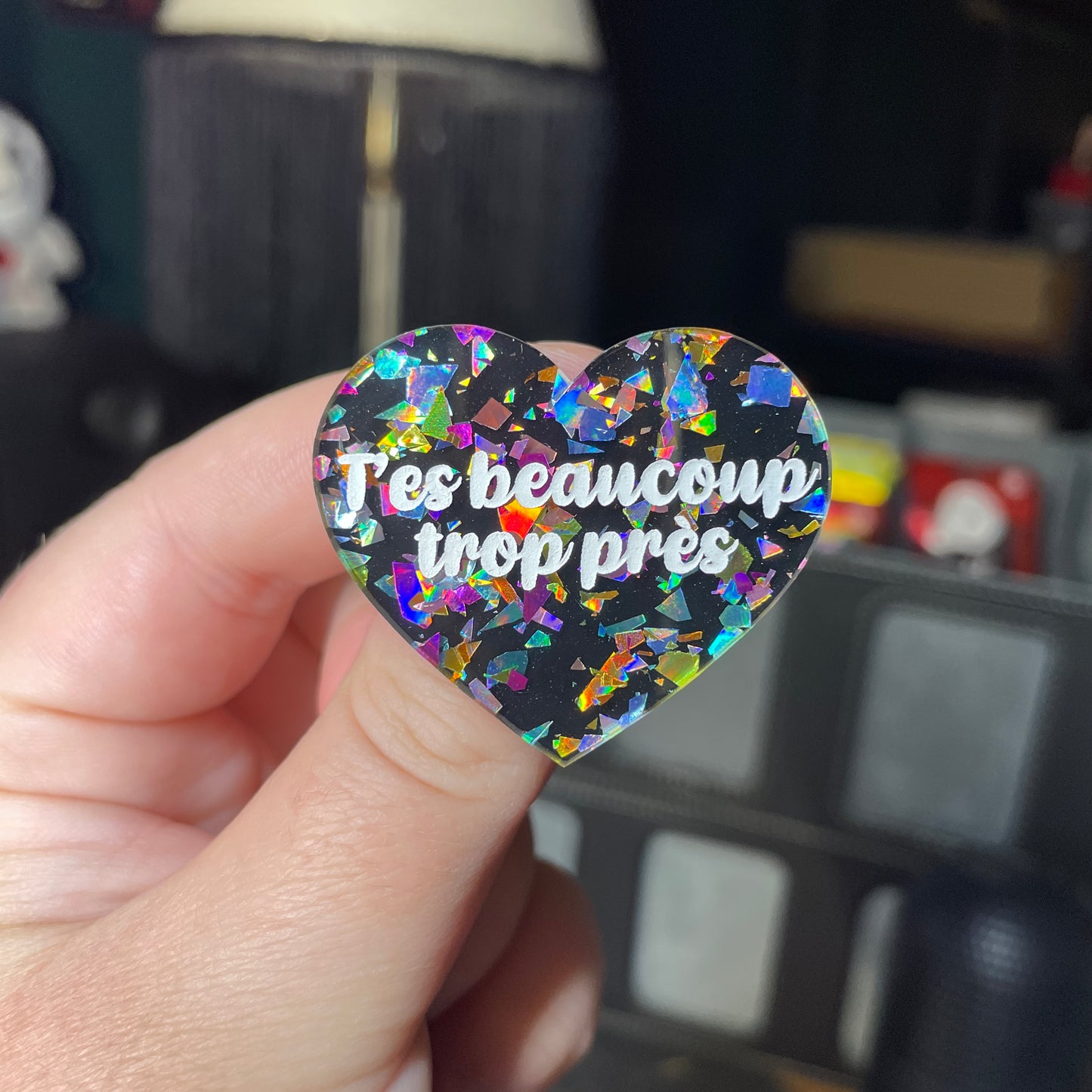 Broche "T'es beaucoup trop près" en acrylique noire avec des éclats de confettis multicolores
