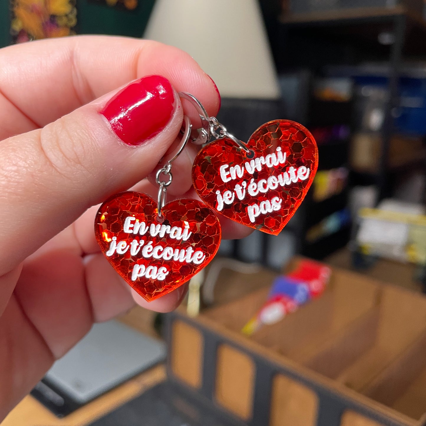 Paire de boucles d'oreilles "En vrai je t'écoute pas" en acrylique semi transparente avec des confettis rouges