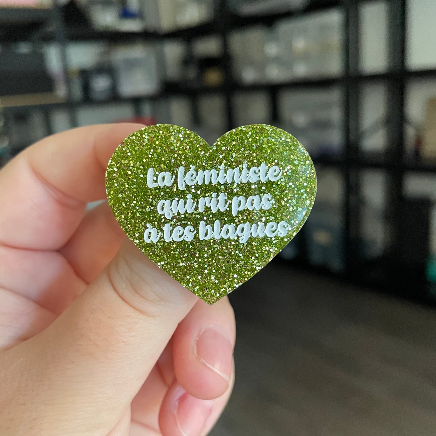 Broche "La féministe qui rit pas à tes blagues" en acrylique à paillettes vertes