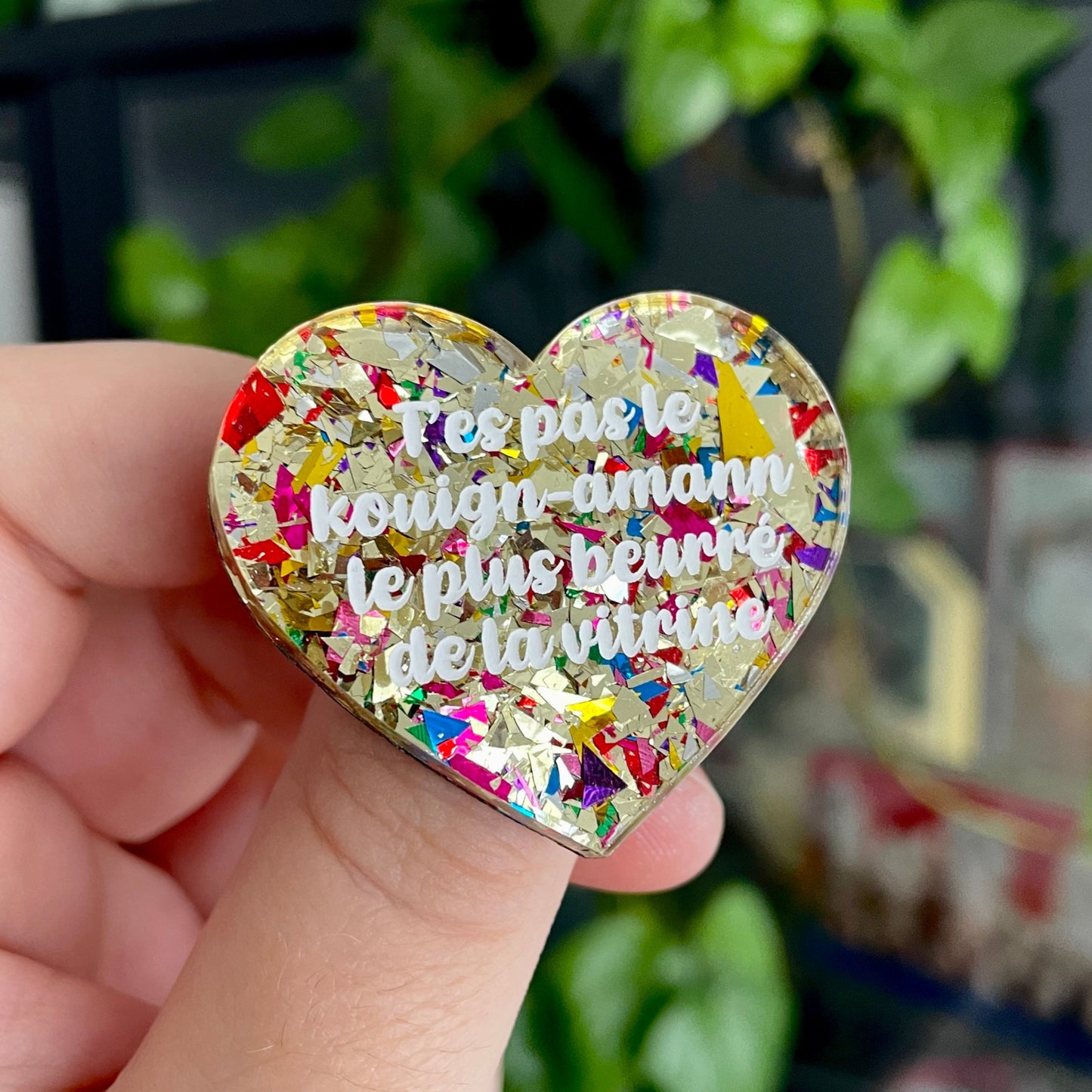 Broche "T'es pas le kouign-amann le plus beurré de la vitrine" en acrylique avec des éclats de confettis dorés et multicolores