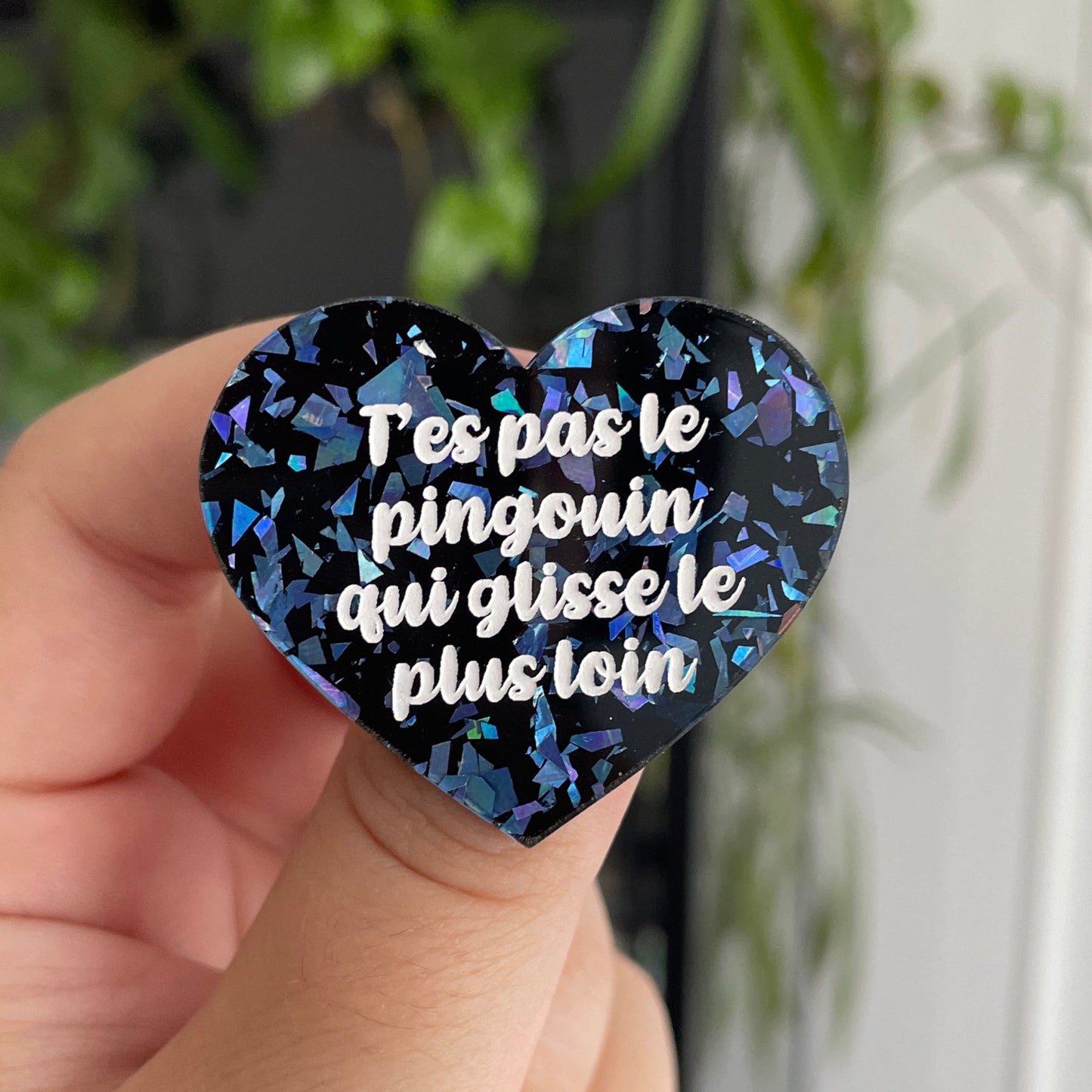 Broche "T'es pas le pingouin qui glisse le plus loin" en acrylique noire avec des éclats de confettis bleus
