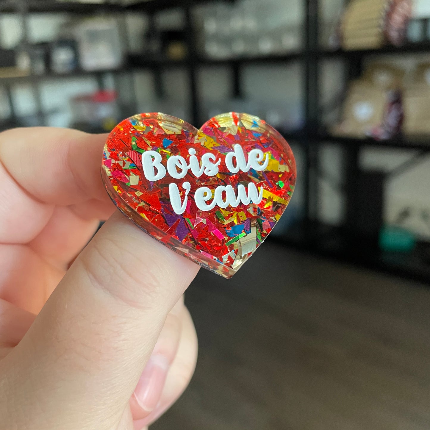 Broche "Bois de l'eau" en acrylique transparente avec des éclats de confettis rouges et multicolores