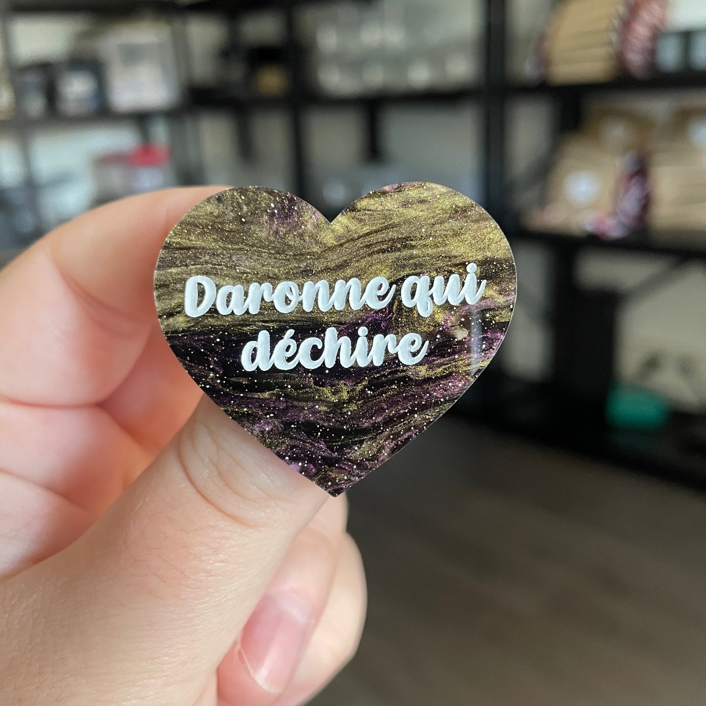 Broche "Daronne qui déchire" en acrylique marbrée noire, dorée et violette à paillettes
