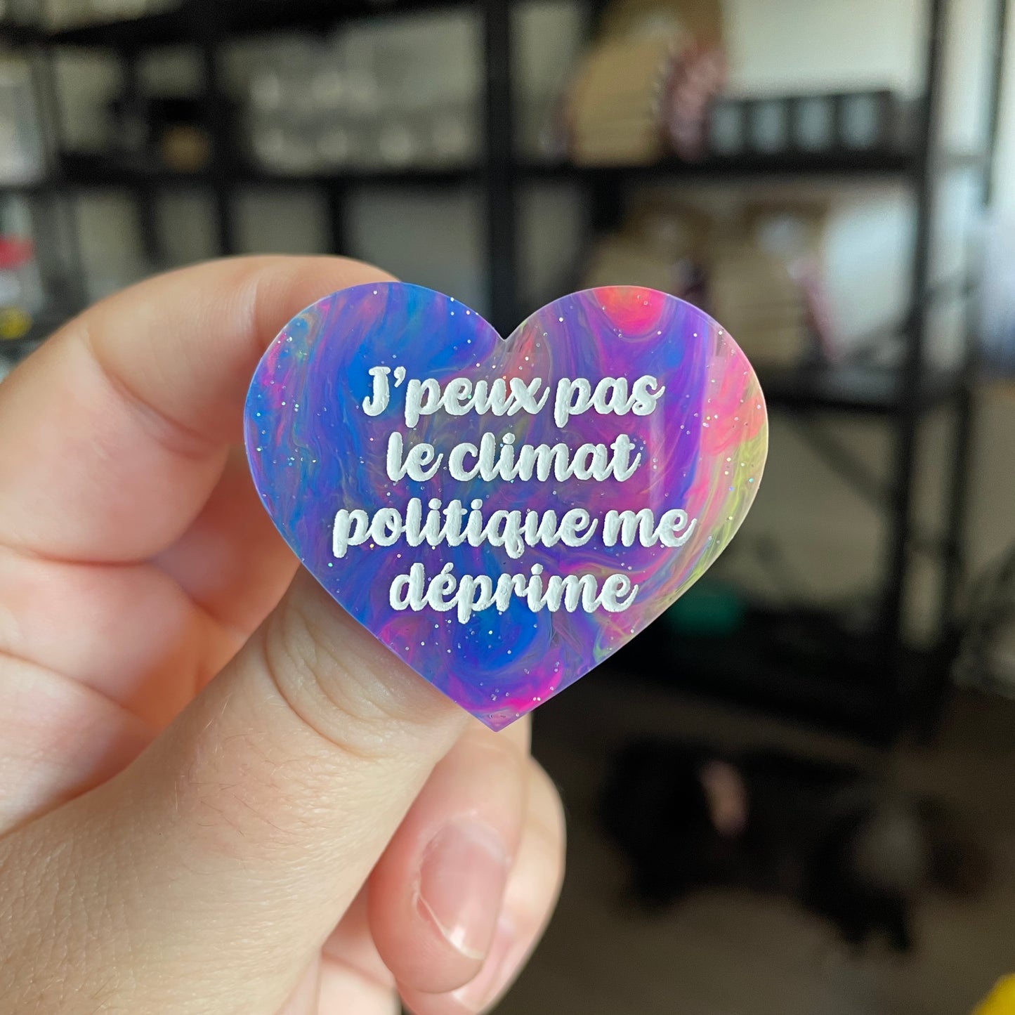 Broche "J'peux pas le climat politique me déprime" en acrylique semi transparente marbrée multicolore