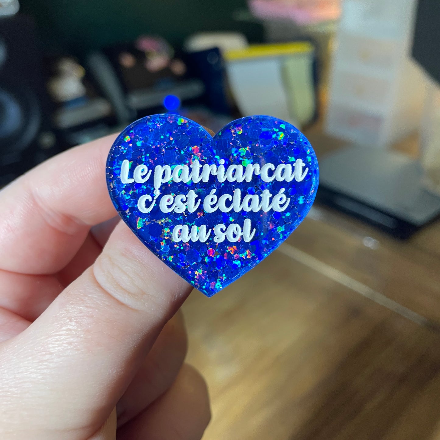 Broche "Le patriarcat c'est éclaté au sol" en acrylique semi transparente à paillettes bleues