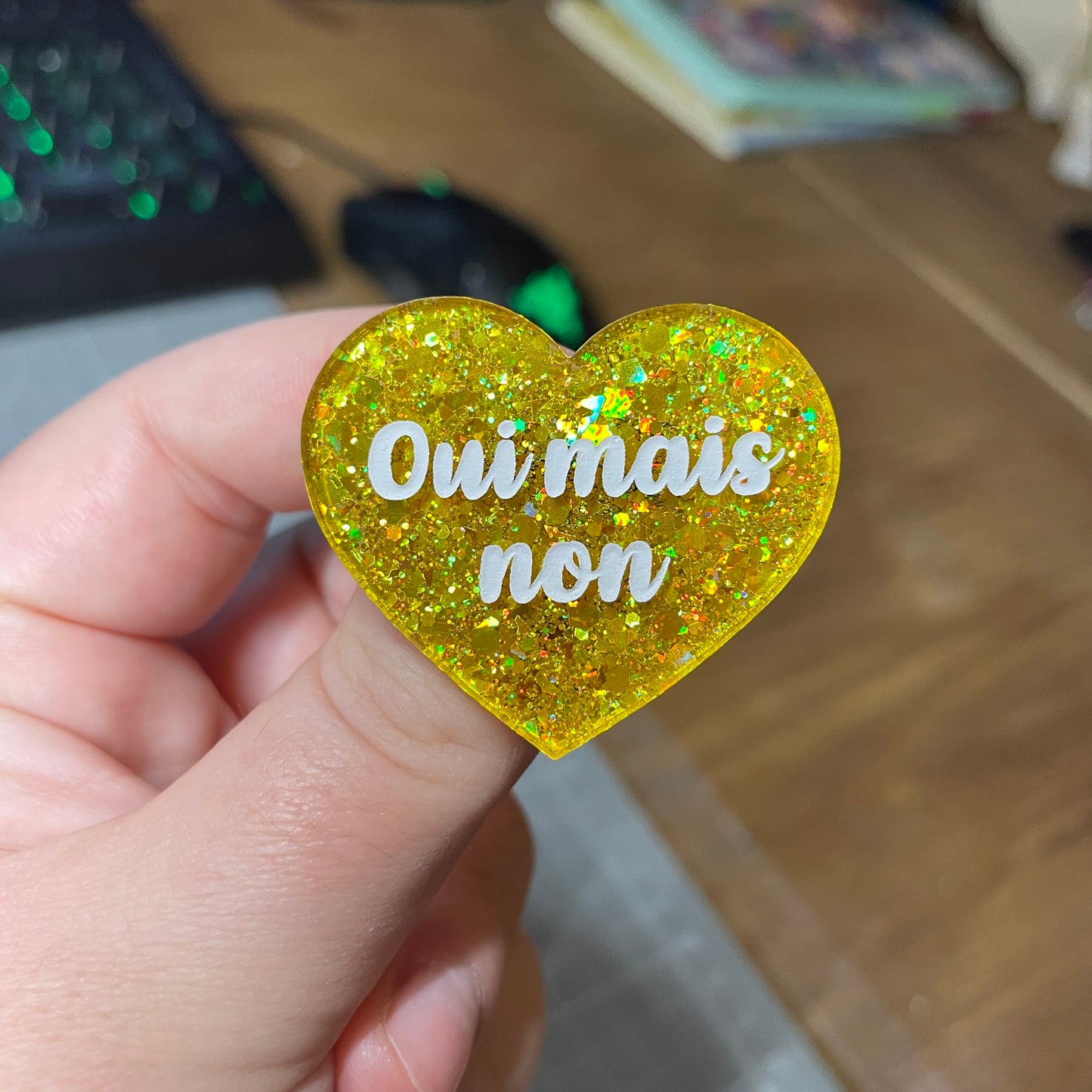 Broche "Oui mais non" en acrylique semi transparente avec des paillettes jaunes