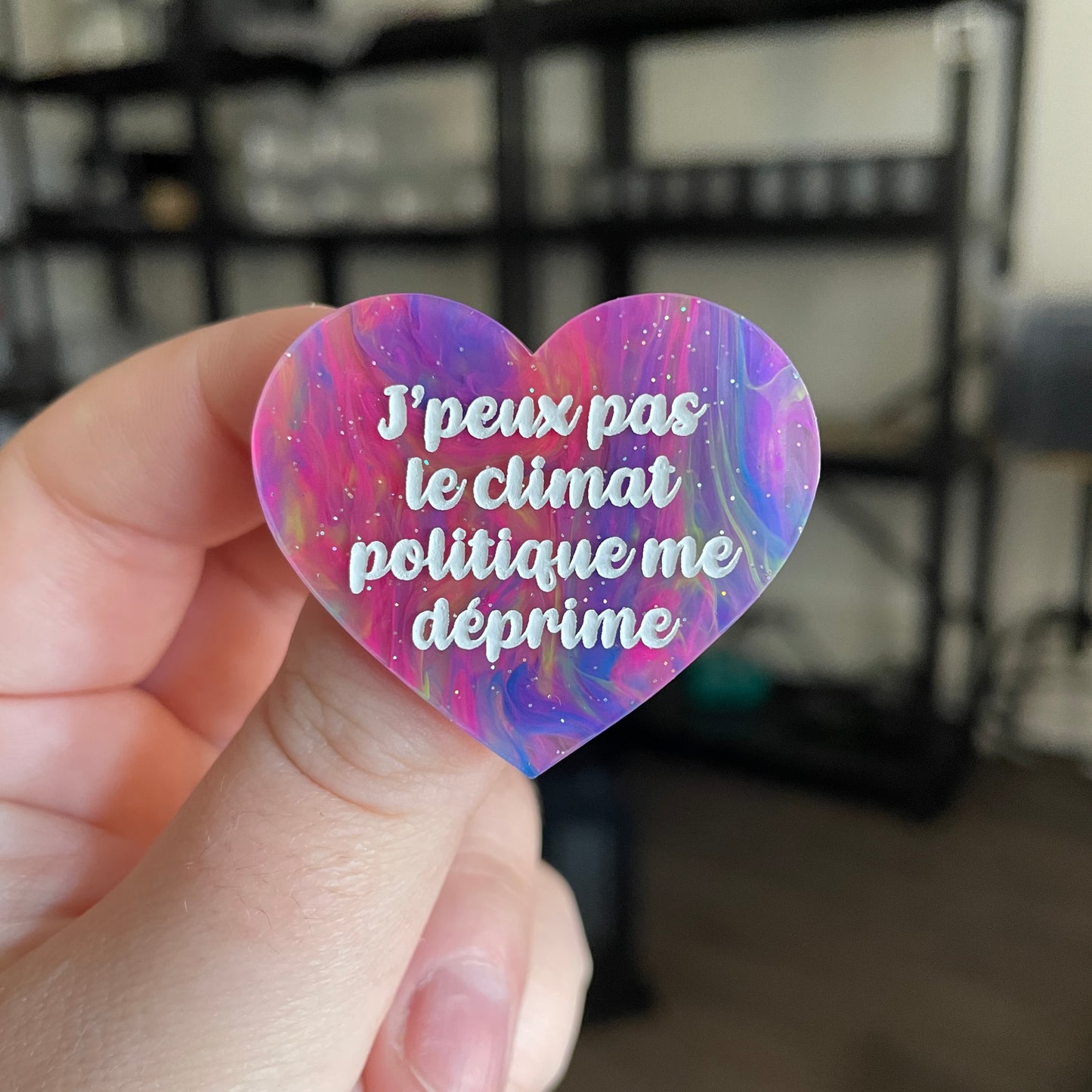 Broche "J'peux pas le climat politique me déprime" en acrylique semi transparente marbrée multicolore
