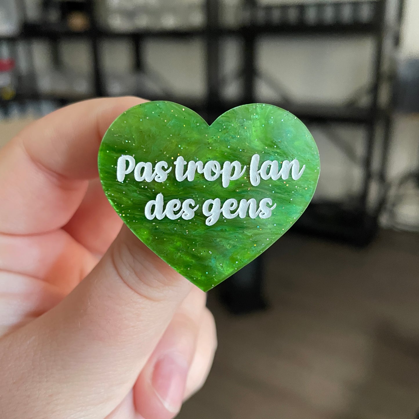 Broche "Pas trop fan des gens" en acrylique marbrée verte à paillettes