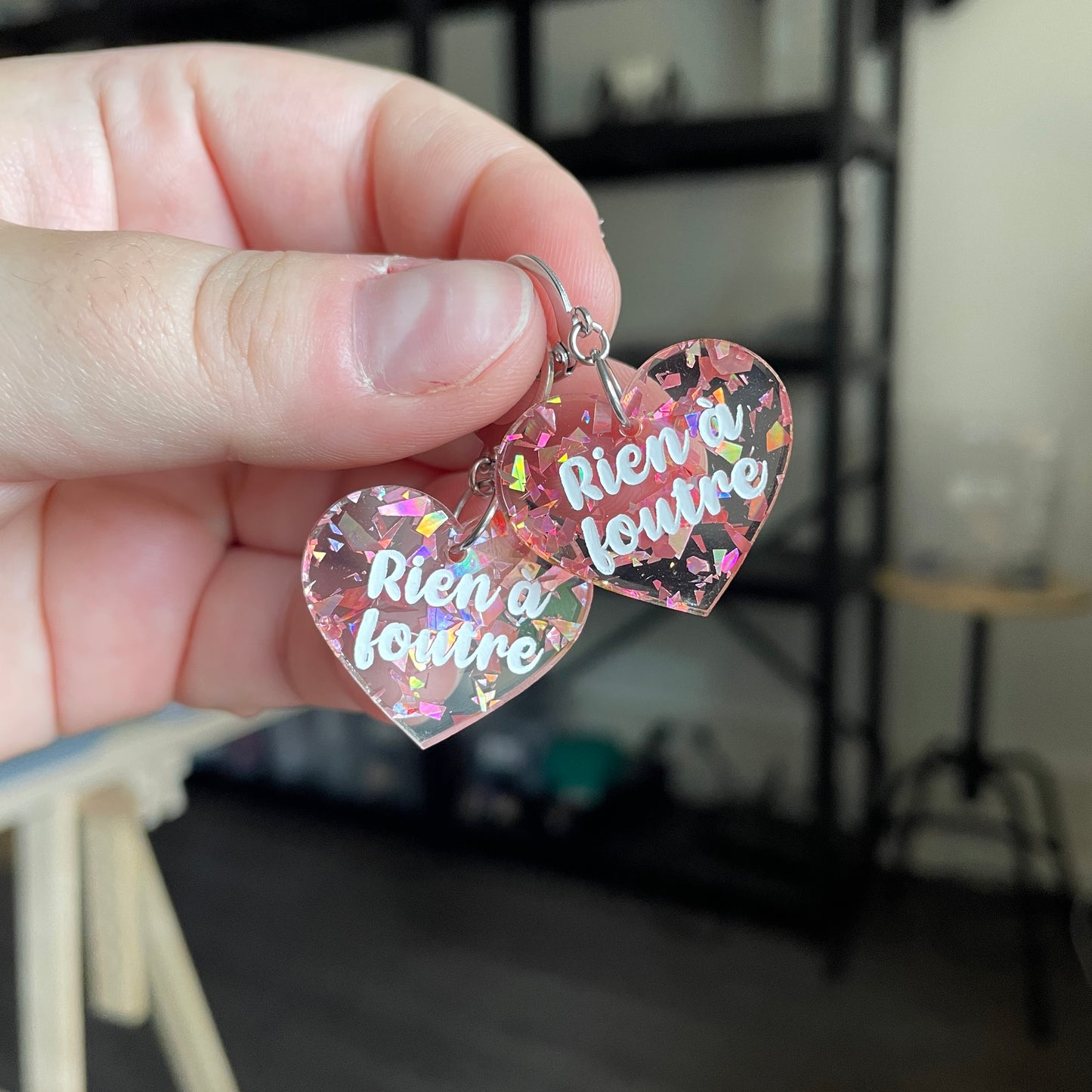 Petites boucles d'oreilles coeurs pendantes "Rien à foutre" en acrylique transparente avec des éclats de confettis corail