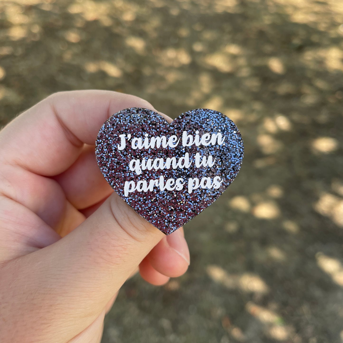 Broche "J'aime bien quand tu parles pas" en acrylique à paillettes grises