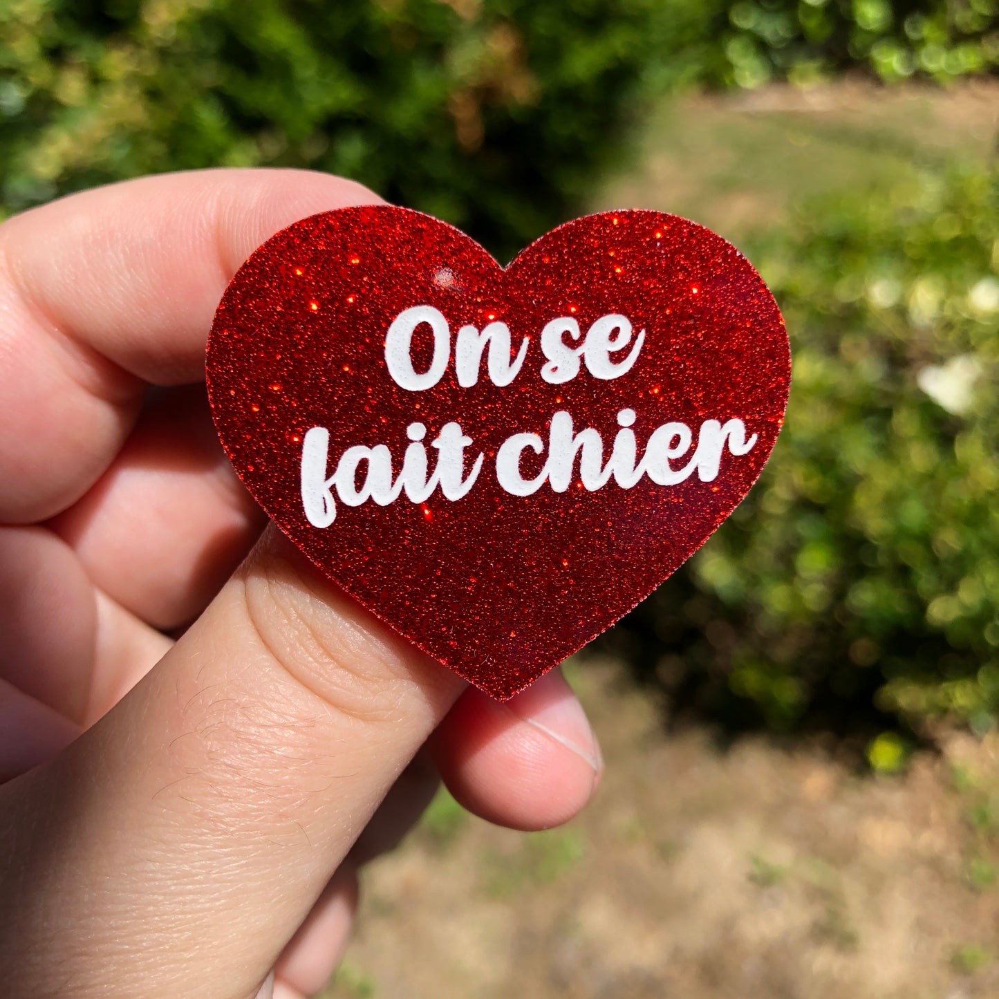 Broche "On se fait chier" en acrylique à paillettes rouges