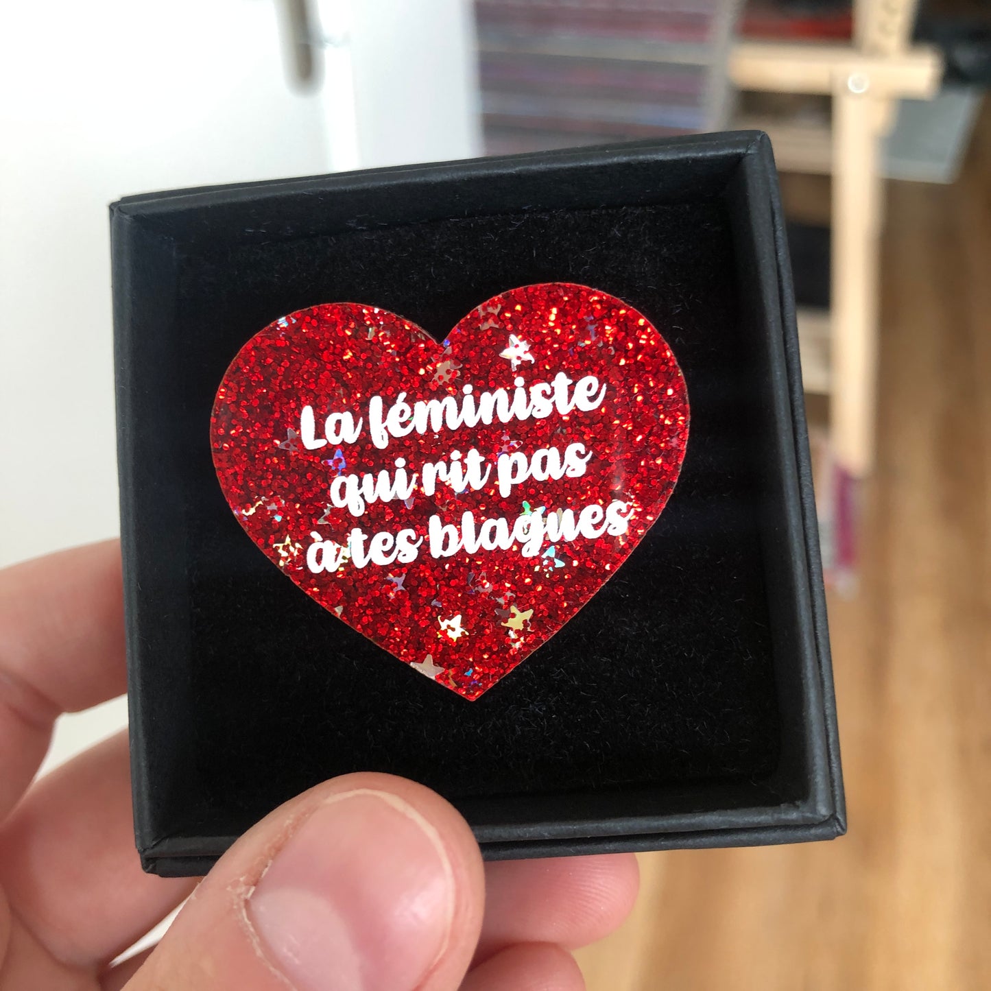 Broche "La féministe qui rit pas à tes blagues" en acrylique à paillettes rouges et étoiles