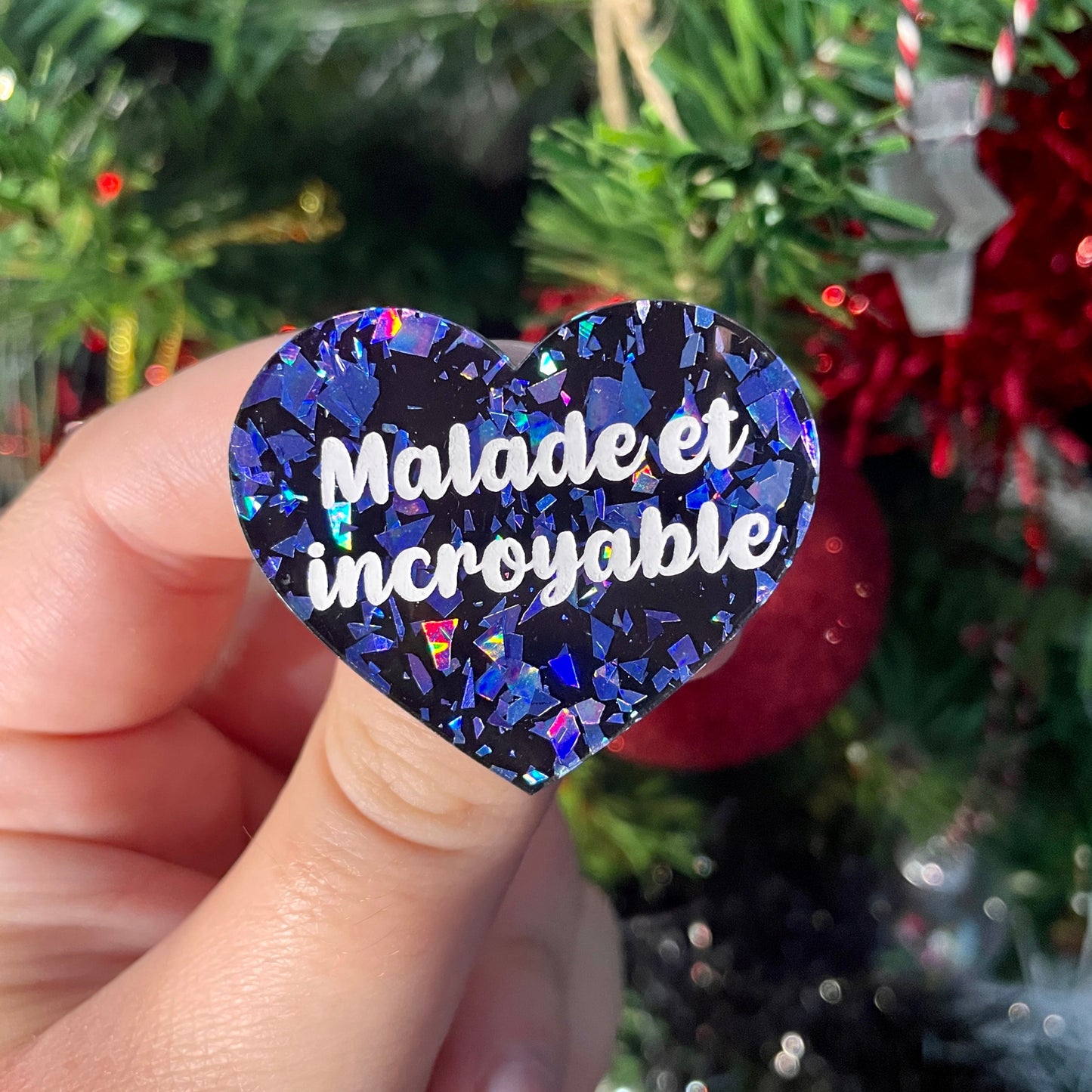 Broche "Malade et incroyable" en acrylique noire à confettis galactiques bleus