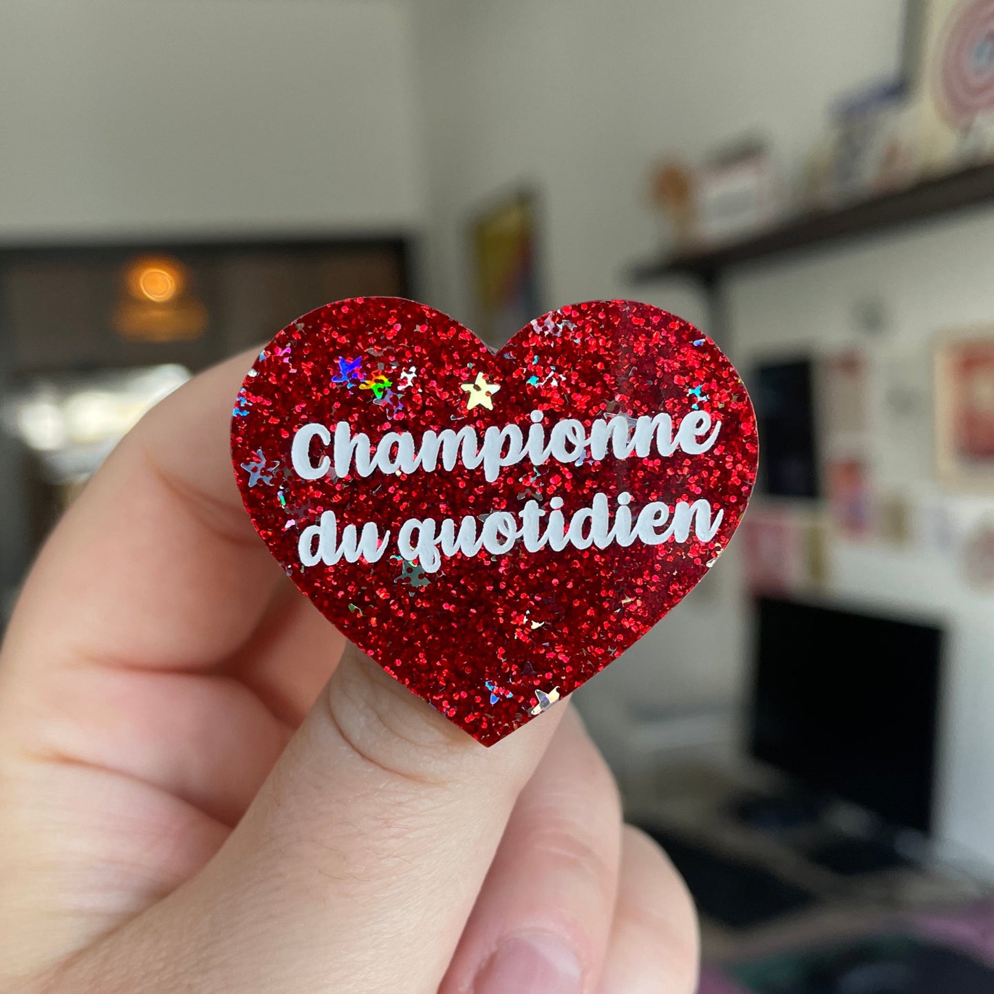 Broche "Championne du quotidien" en acrylique à paillettes rouges et étoiles holographiques