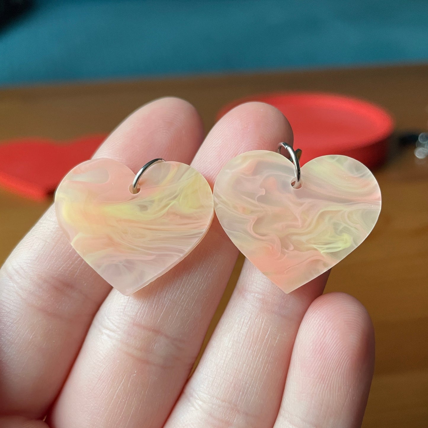 Petites boucles d'oreilles coeurs pendantes en acrylique marbrée orange/jaune