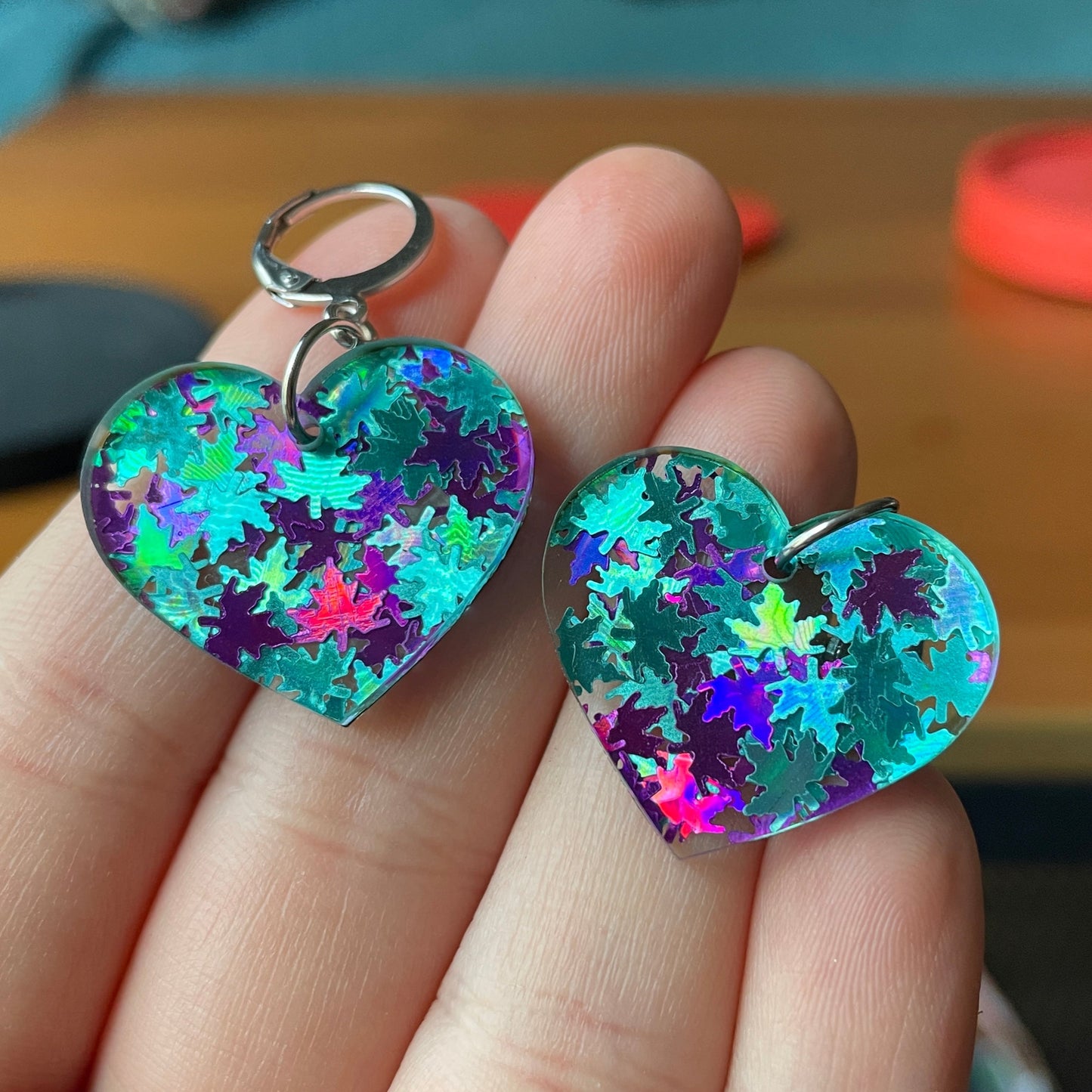 Petites boucles d'oreilles coeurs pendantes en acrylique avec des confettis feuilles d'érable bleues et violettes