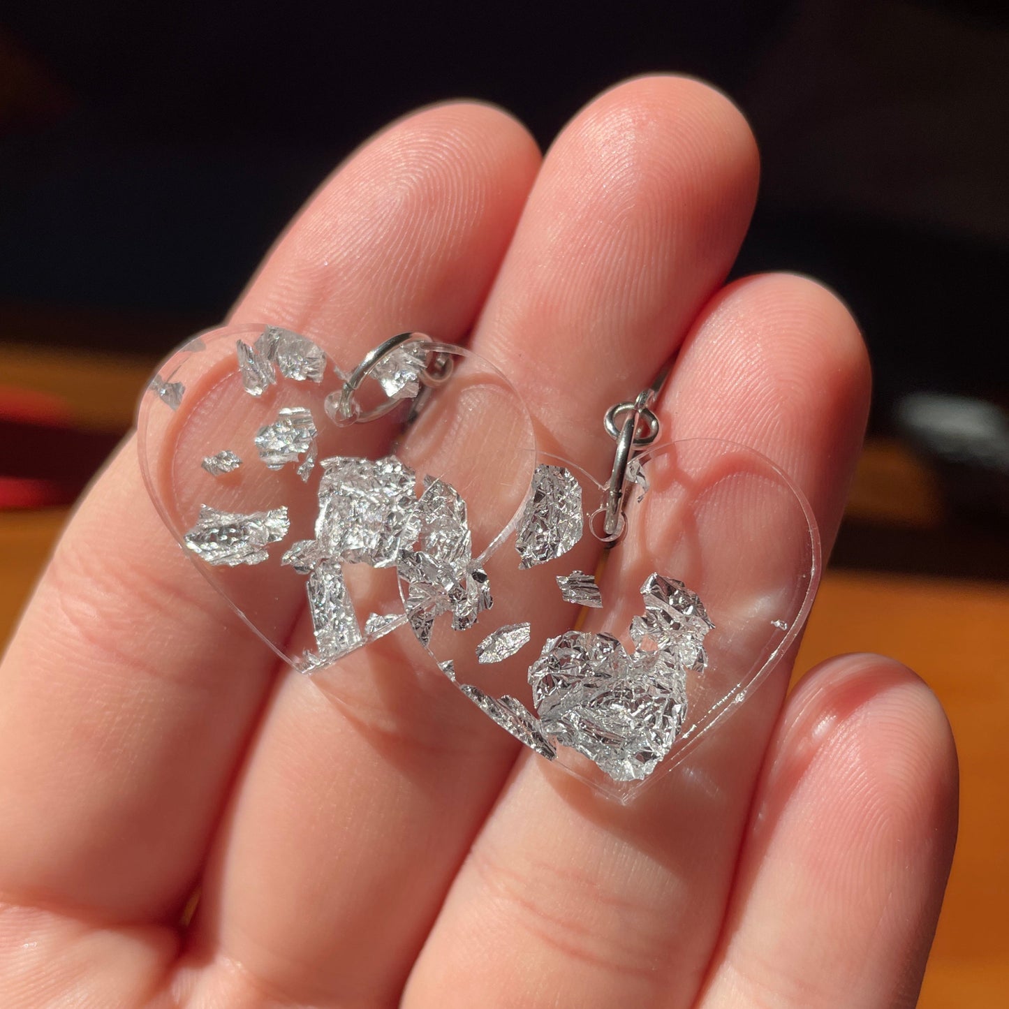 Petites boucles d'oreilles coeurs pendantes en acrylique transparente avec des éclats de feuilles argentées