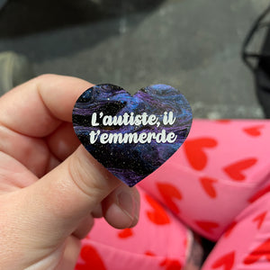Broche "L’autiste il t’emmerde" en acrylique marbrée bleue, noire et violette à paillettes