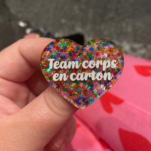 Broche "Team corps en carton" en acrylique semi-transparente avec des confettis étoiles multicolores
