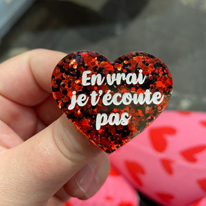 Broche "En vrai je t’écoute pas" en acrylique semi-transparente avec des pois rouges et noirs