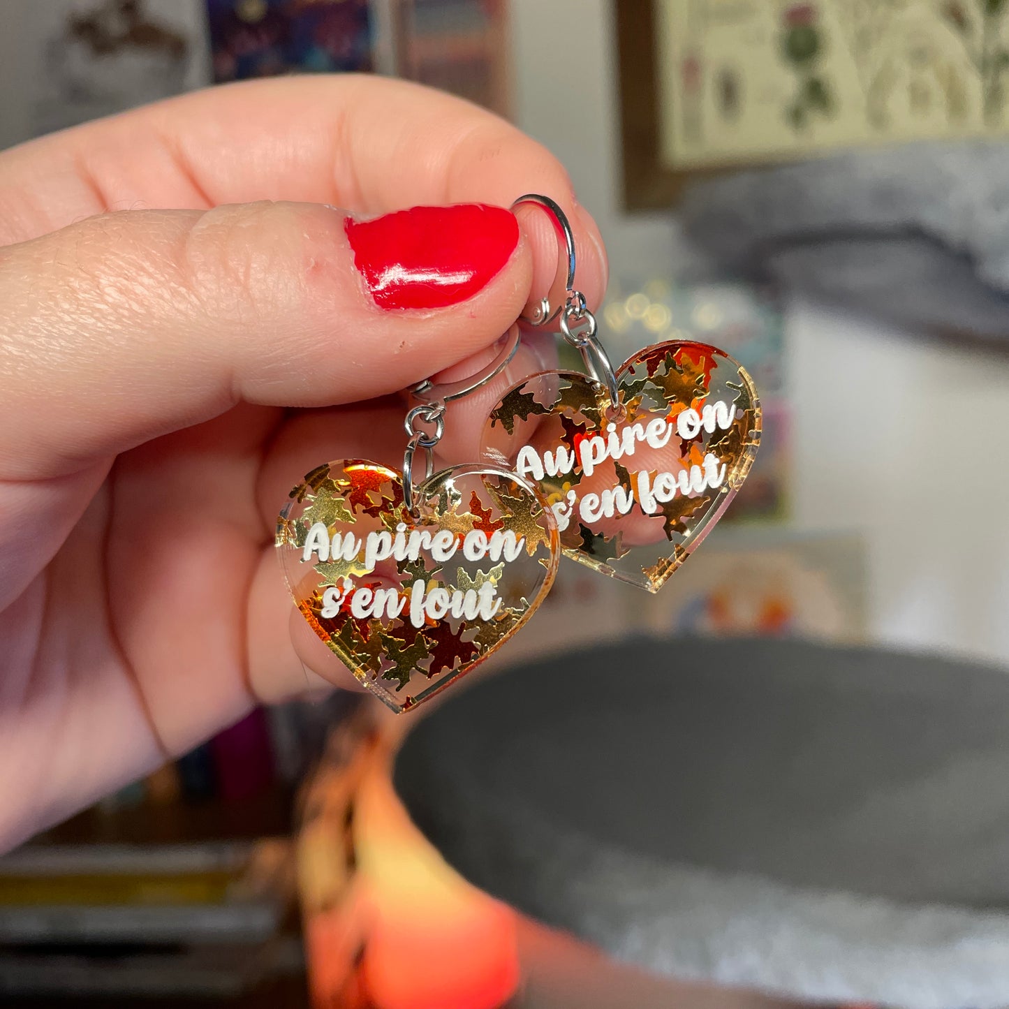 Petites boucles d'oreilles coeurs pendantes "Au pire on s'en fout" en acrylique transparente avec des confettis feuilles d'érable