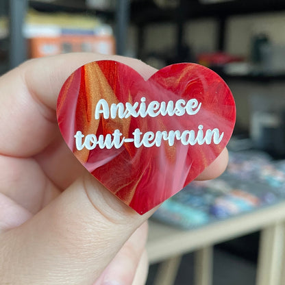 Broche "Anxieuse tout-terrain" en acrylique marbrée rouge, blanche et dorée
