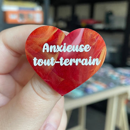 Broche "Anxieuse tout-terrain" en acrylique marbrée rouge, blanche et dorée