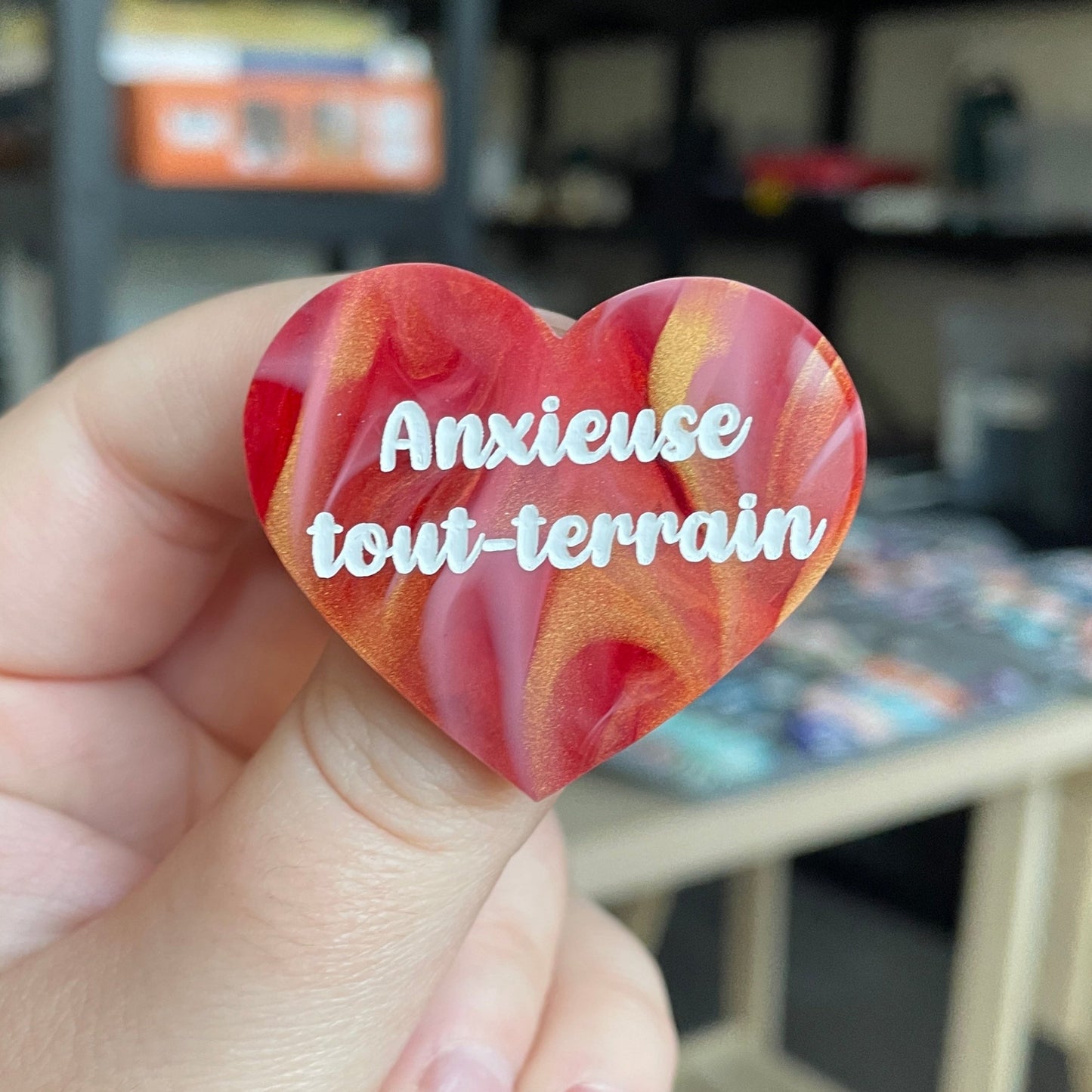 Broche "Anxieuse tout-terrain" en acrylique marbrée rouge, blanche et dorée