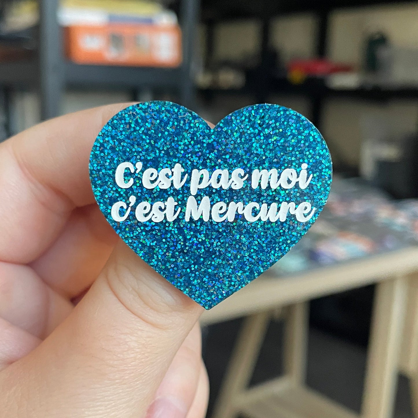 Broche "C'est pas moi, c'est Mercure" en acrylique à paillettes bleues
