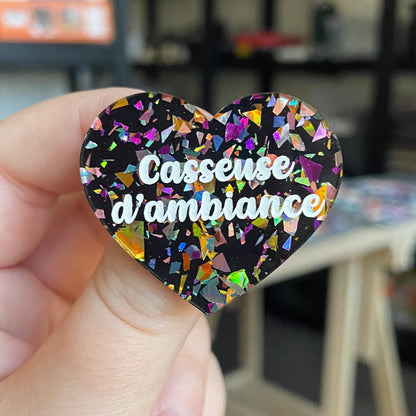 Broche "Casseuse d'ambiance" en acrylique noire avec des éclats de confettis multicolores