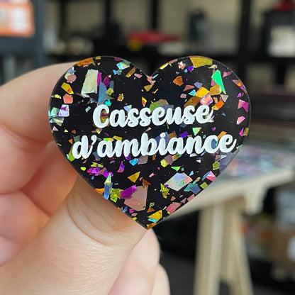 Broche "Casseuse d'ambiance" en acrylique noire avec des éclats de confettis multicolores