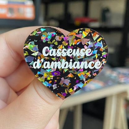 Broche "Casseuse d'ambiance" en acrylique noire avec des éclats de confettis multicolores