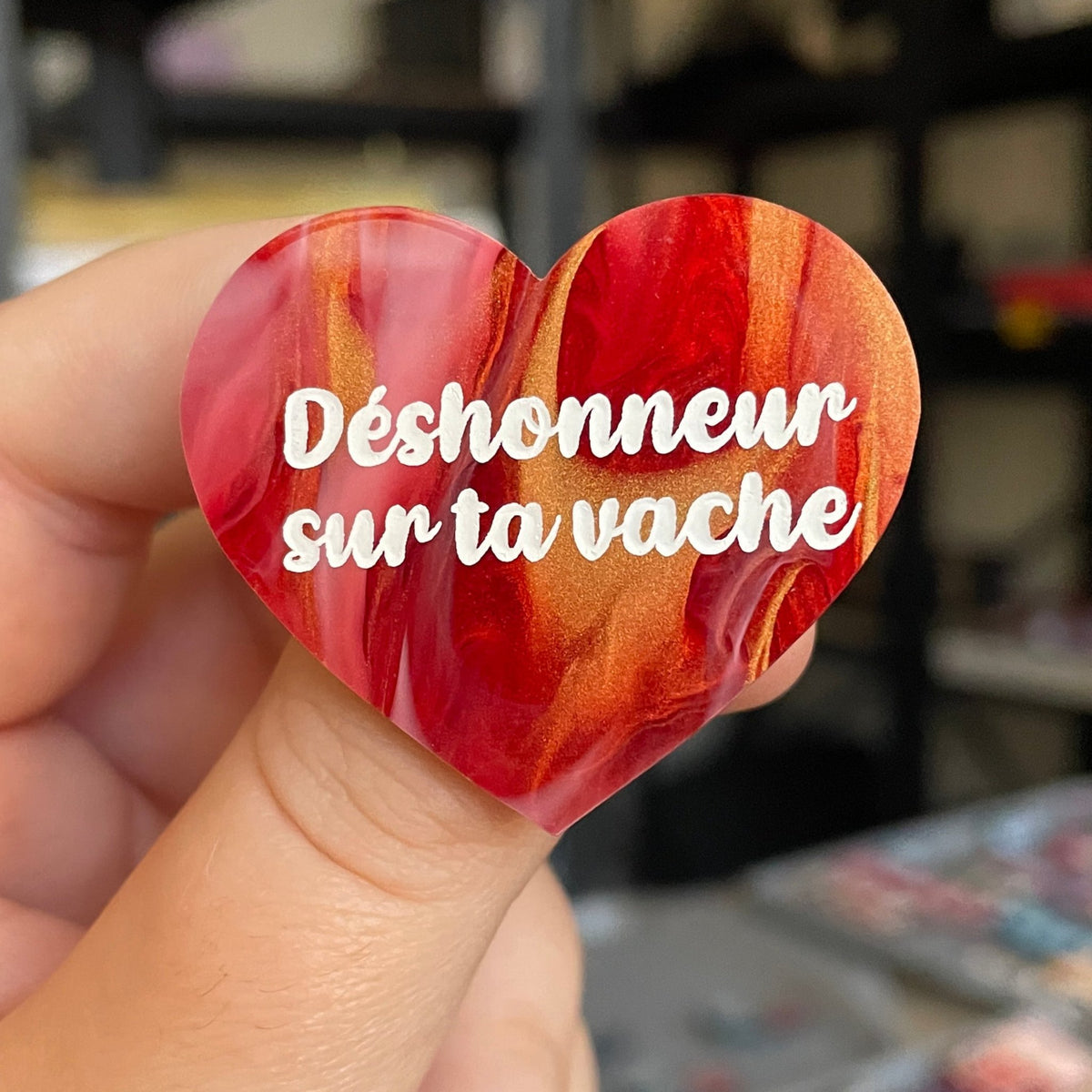 Broche "Déshonneur sur ta vache" en acrylique marbrée rouge, blanche et dorée