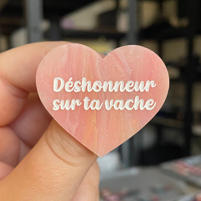 Broche "Déshonneur sur ta vache" en acrylique marbrée semi-transparente orange, corail, blanche et jaune à paillettes