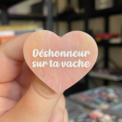 Broche "Déshonneur sur ta vache" en acrylique marbrée semi-transparente orange, corail, blanche et jaune à paillettes