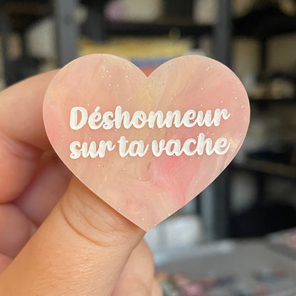 Broche "Déshonneur sur ta vache" en acrylique marbrée semi-transparente orange, corail, blanche et jaune à paillettes