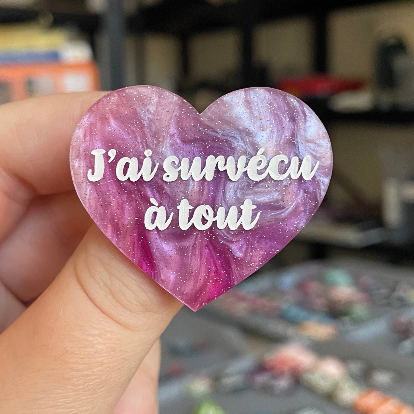 Broche "J'ai survécu à tout" en acrylique marbrée violette, rose et blanche