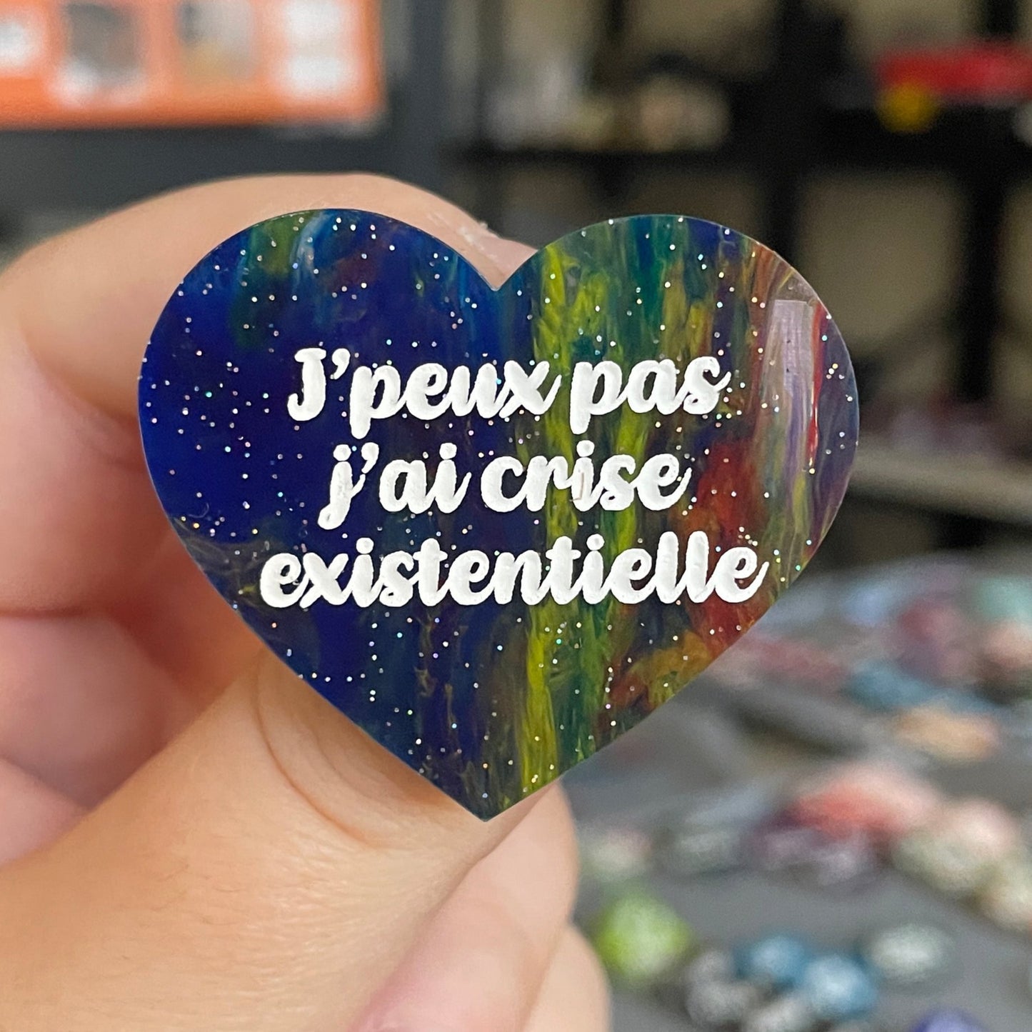 Broche "J'peux pas j'ai crise existentielle" en acrylique marbrée semi-transparente bleue et multicolore