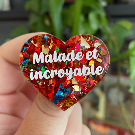 Broche "Malade et incroyable" en acrylique avec des éclats de confettis rouges et multicolores